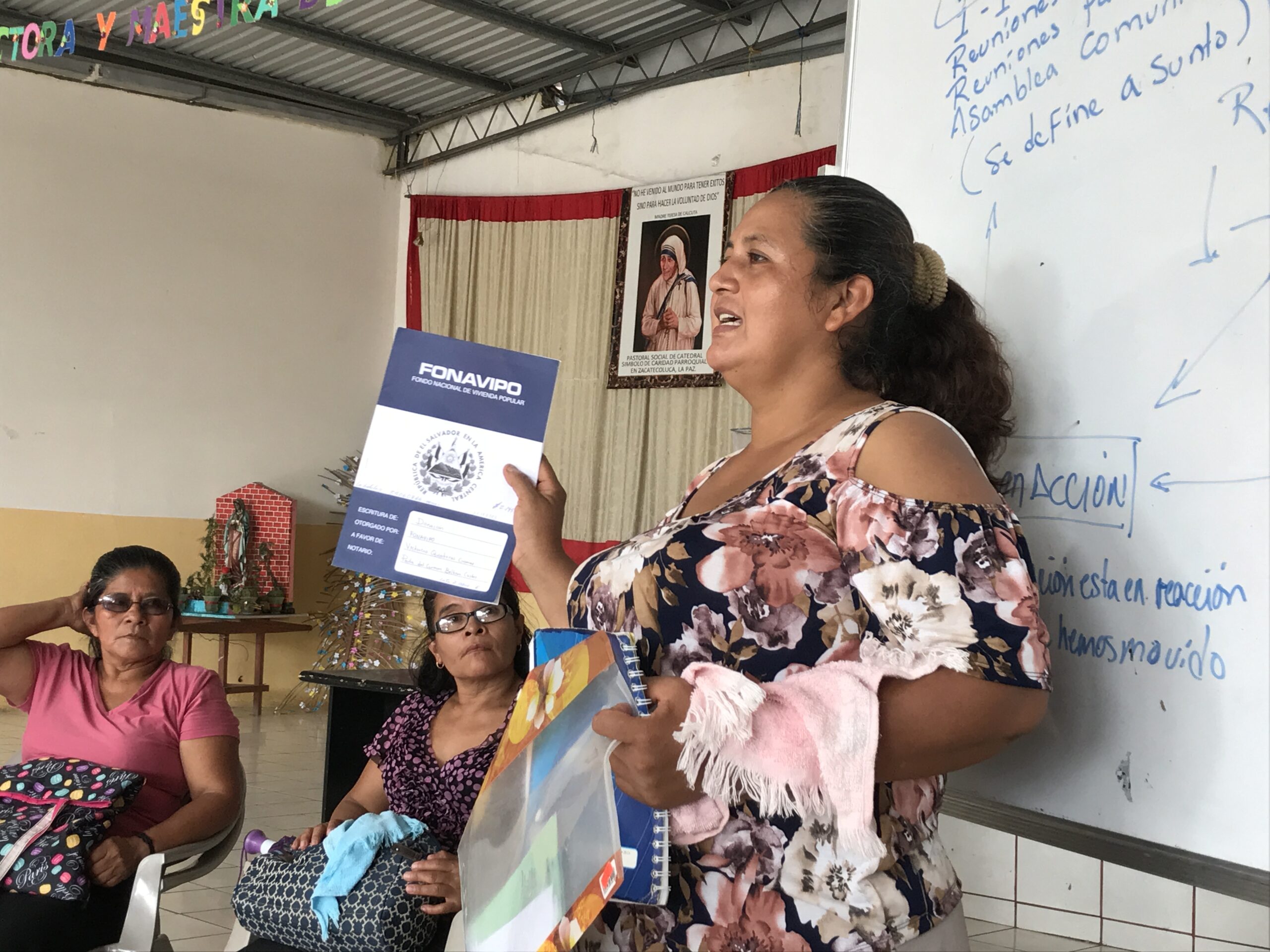 Woman standing in front of a white board educating locals on their rights.